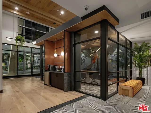 a view of a hall with furniture and floor to ceiling window