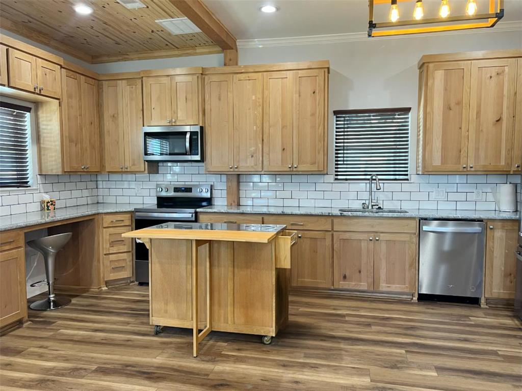 724 Franklin Street Bellevue, TX 76228 - Photo 11 of 32 a kitchen with stainless steel appliances granite countertop a stove sink microwave and cabinets