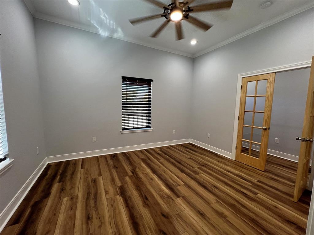 724 Franklin Street Bellevue, TX 76228 - Photo 16 of 32 wooden floor in an empty room with a window