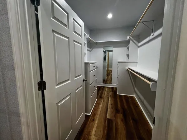 en empty room with wooden floor chandelier fan and windows