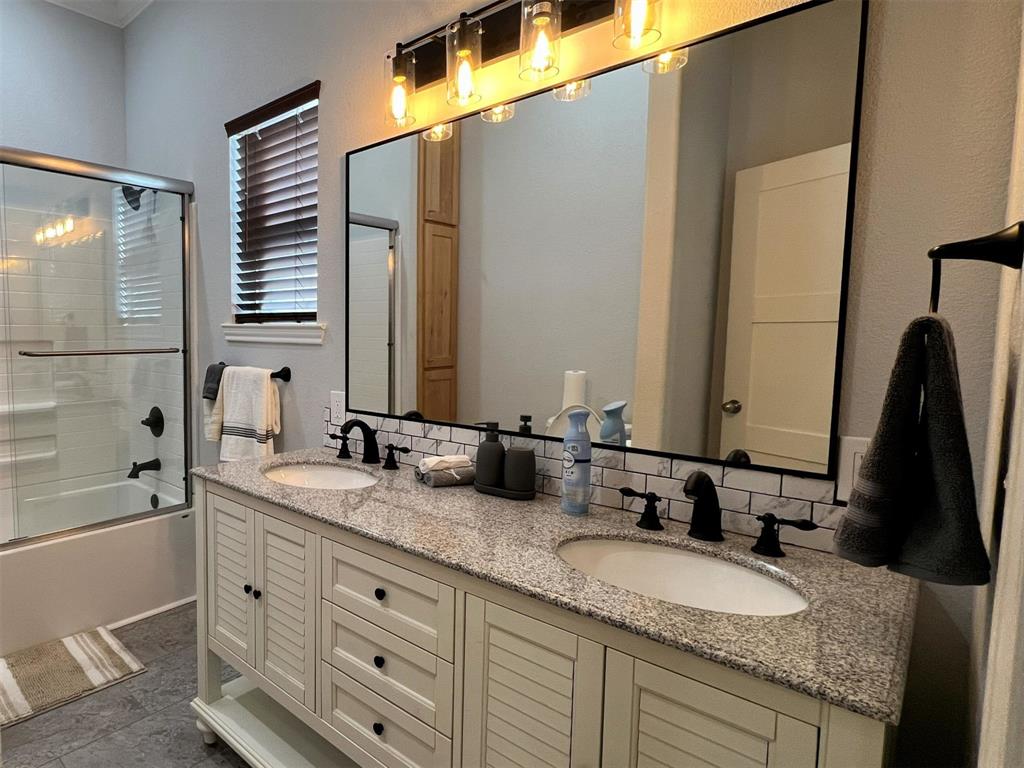 724 Franklin Street Bellevue, TX 76228 - Photo 19 of 32 a bathroom with a granite countertop double vanity sink and mirror