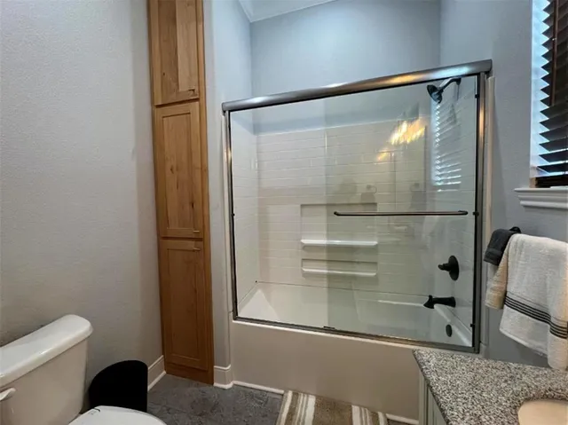 a bathroom with a granite countertop double vanity sink and mirror