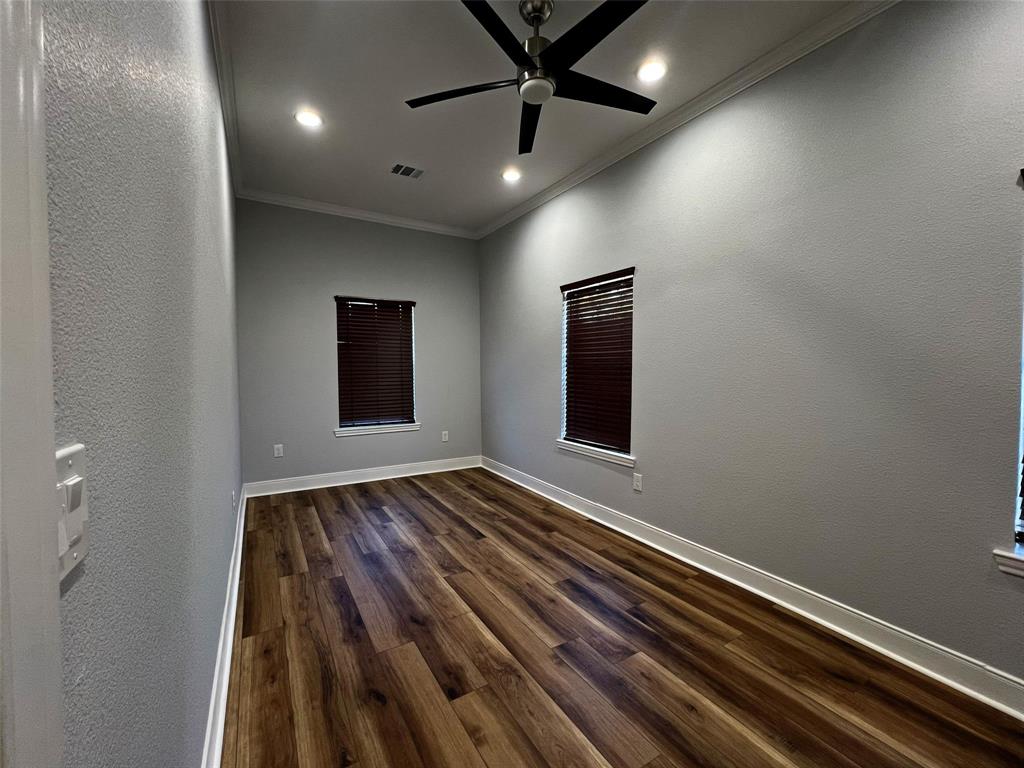 724 Franklin Street Bellevue, TX 76228 - Photo 21 of 32 en empty room with wooden floor and windows