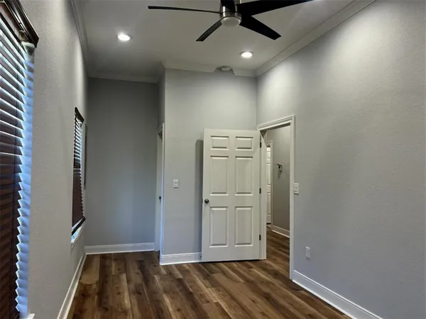 en empty room with wooden floor and windows