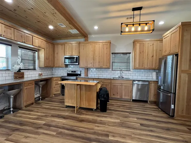 a kitchen with granite countertop a refrigerator stove top oven and sink