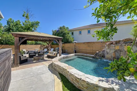 a view of house with swimming pool and garden