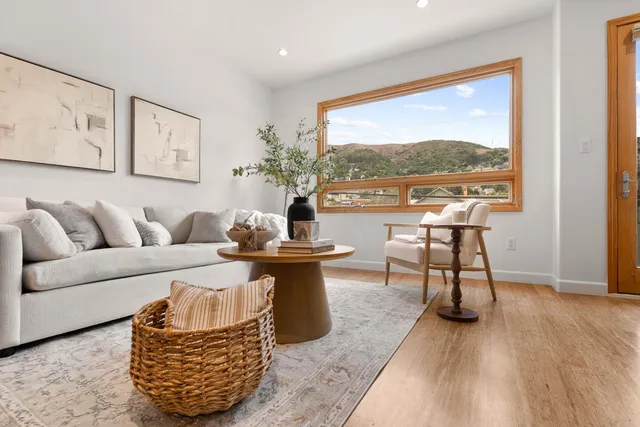a living room with furniture a table and a large window