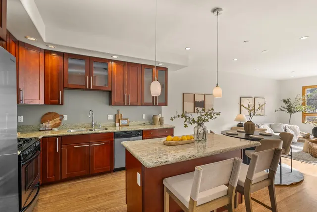 a kitchen with a sink a counter space appliances and cabinets