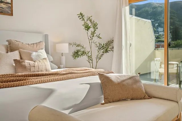 a bedroom with a bed lamp and a potted plant