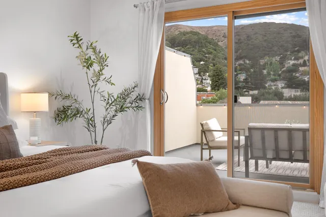 a bedroom with a large window and a bed