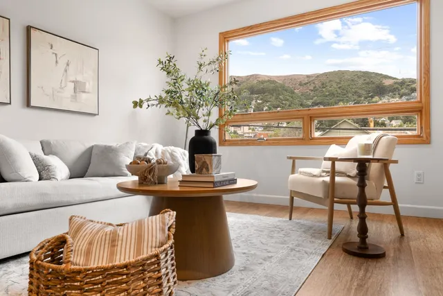a living room with furniture a table and a large window