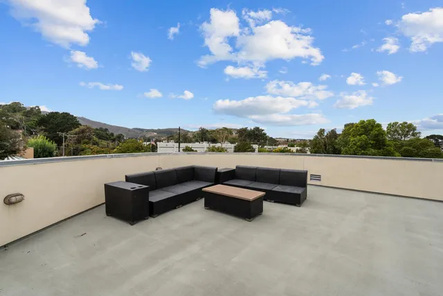 a view of a terrace with couches and sky view