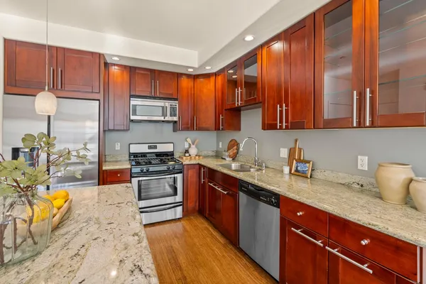 a kitchen with stainless steel appliances granite countertop a stove a sink and a microwave