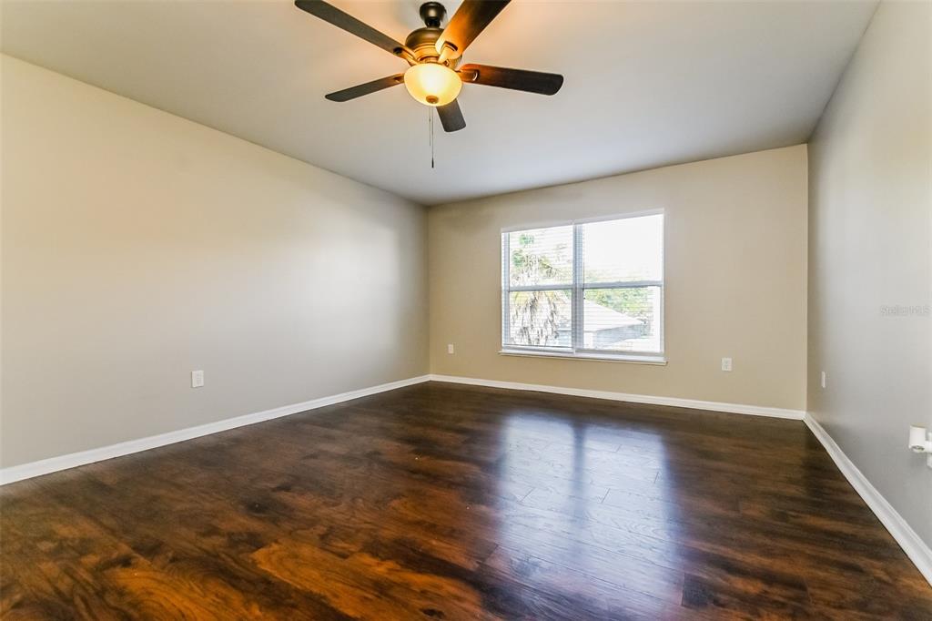10405 Fly Fishing Street Riverview, FL 33569 - Photo 7 of 15 an empty room with wooden floor fan and windows