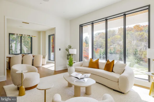 a living room with furniture a table and a large window