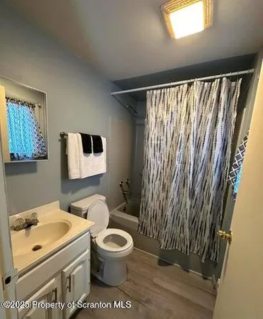 an empty room with a ceiling fan and windows