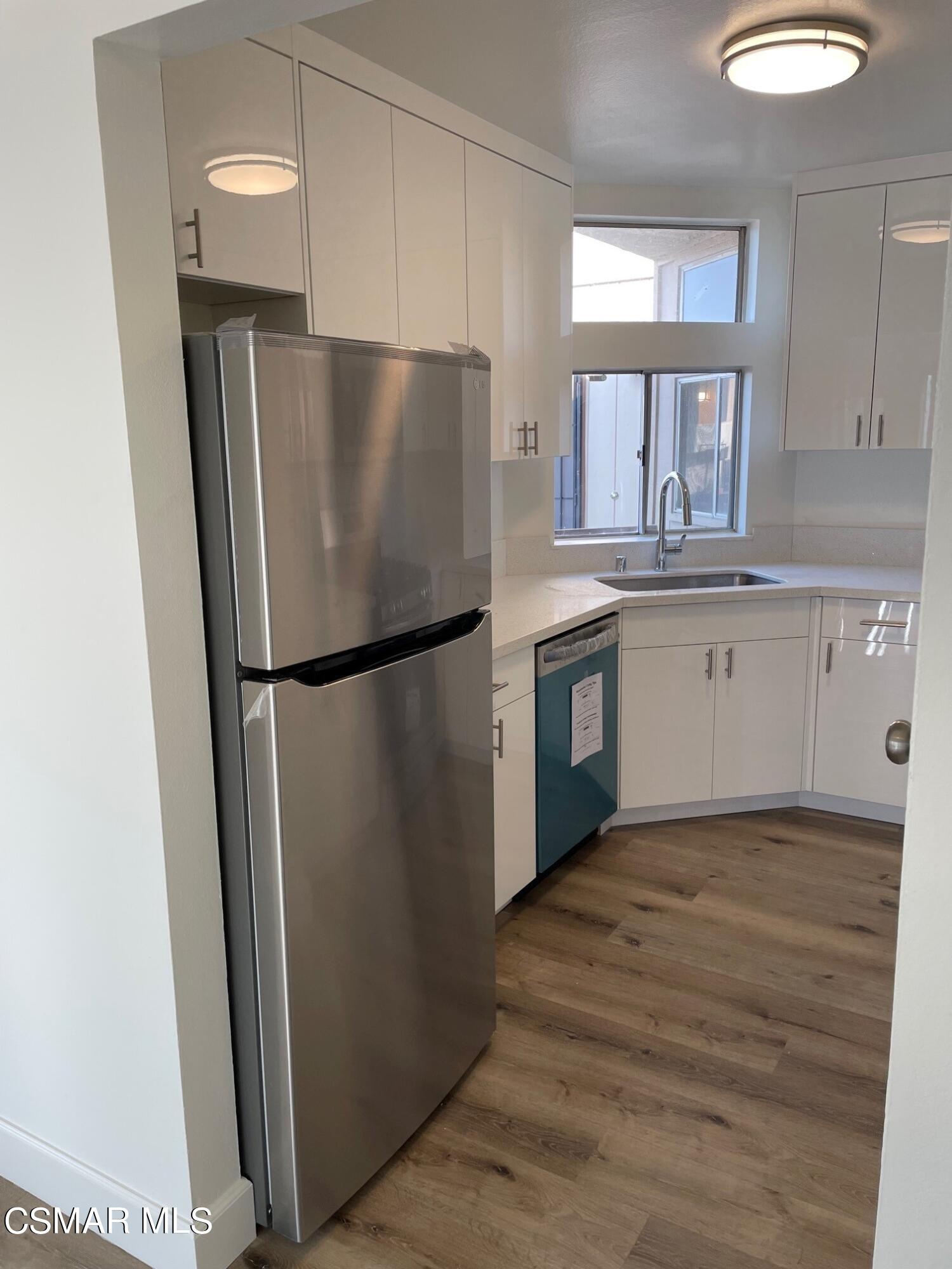 1760 Sinaloa Road, Unit 265 Simi Valley, CA 93065 - Photo 9 of 39 a kitchen with granite countertop a refrigerator a sink and white cabinets