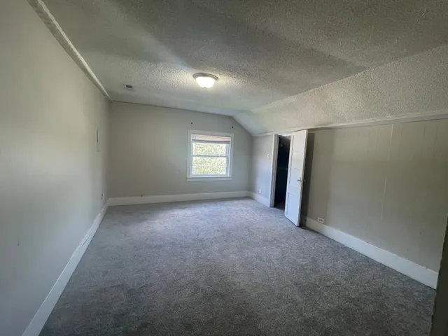 an empty room with windows and closet