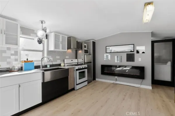 a kitchen with granite countertop white cabinets and stainless steel appliances