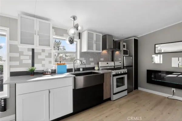 a kitchen with stainless steel appliances granite countertop a sink a stove and a refrigerator