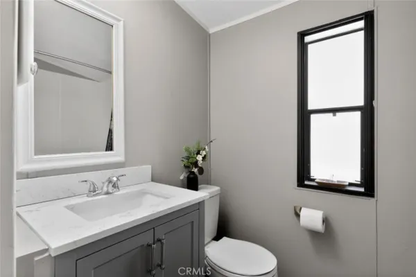 a bathroom with a toilet sink vanity and mirror