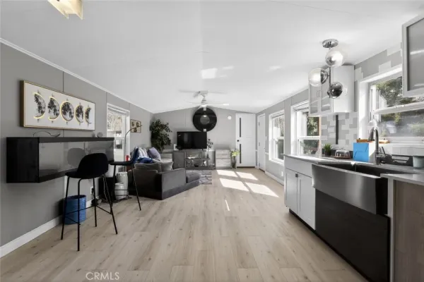 a large living room with stainless steel appliances kitchen view and wooden floor