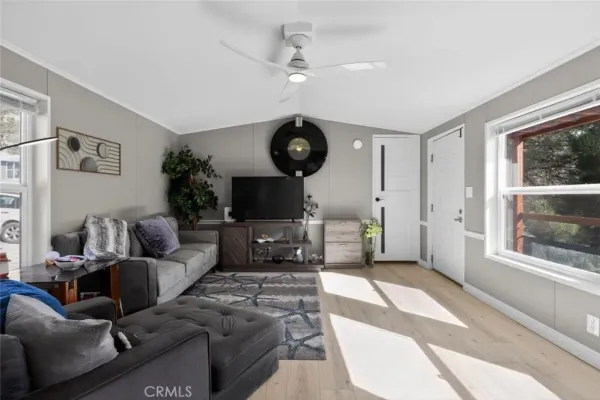 a living room with furniture a flat screen tv and a large window