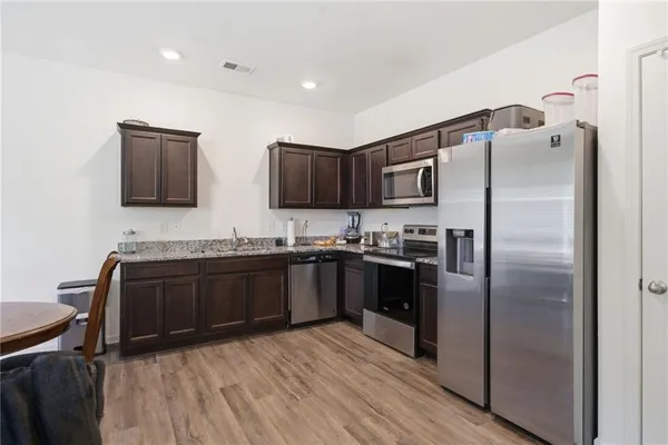 a kitchen with stainless steel appliances granite countertop a refrigerator and a stove top oven