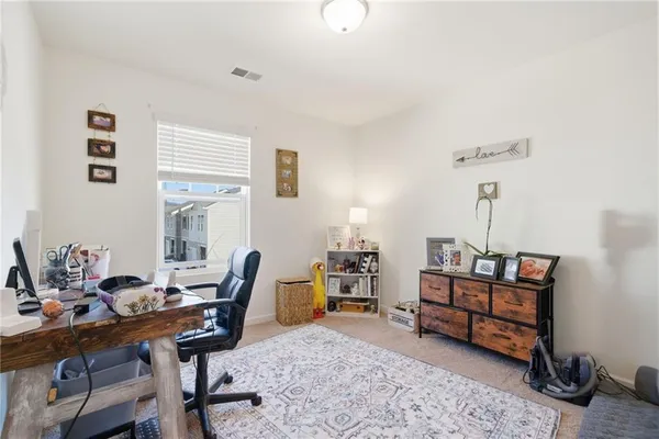 a view of a workspace with furniture and a window