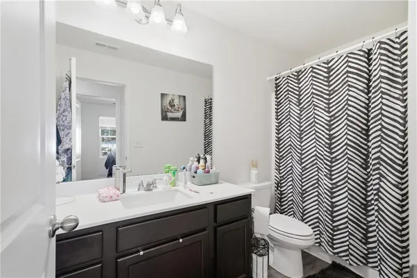 a bathroom with a sink a toilet a mirror and vanity