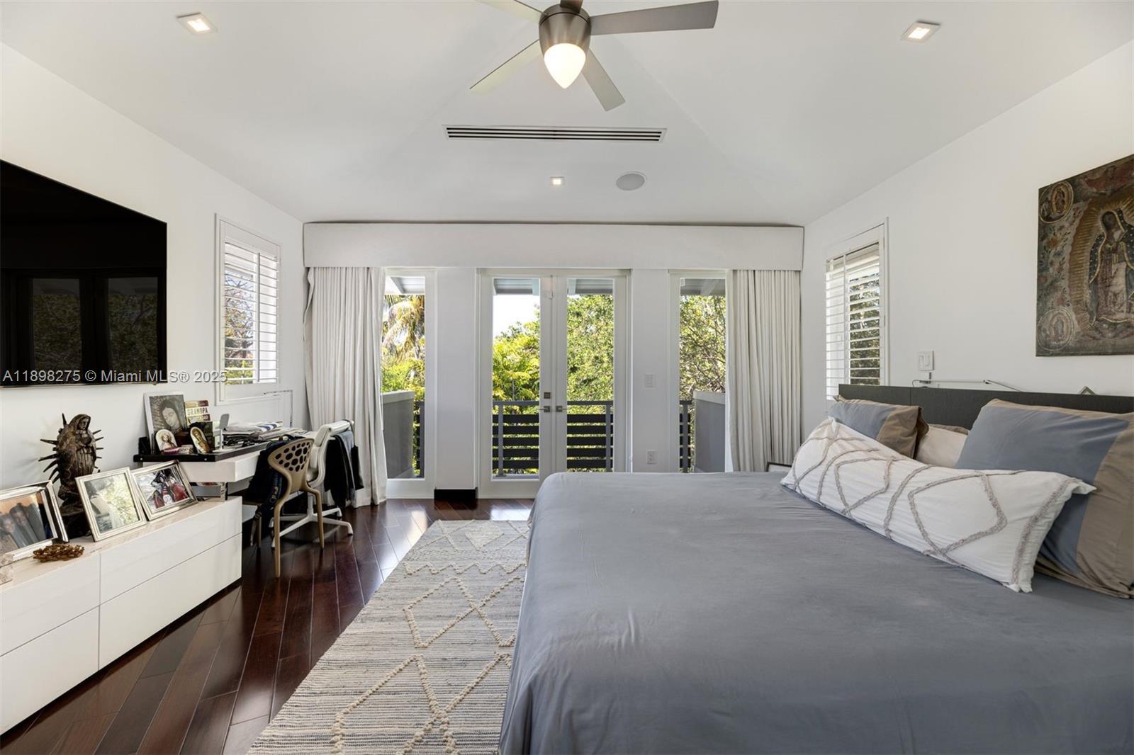 765 Allendale Road Key Biscayne, FL 33149 - Photo 11 of 29 a spacious bedroom with a large bed and a flat screen tv