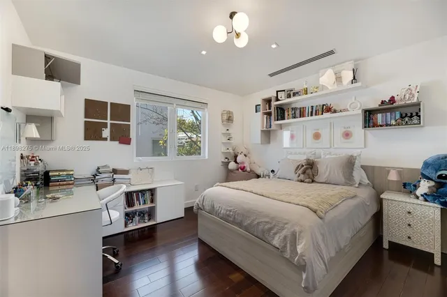 a bedroom with a bed wooden floor and window