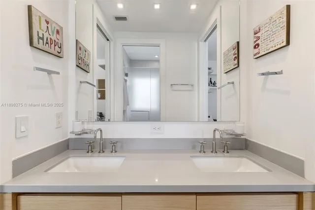a bathroom with double vanity sinks with a tub