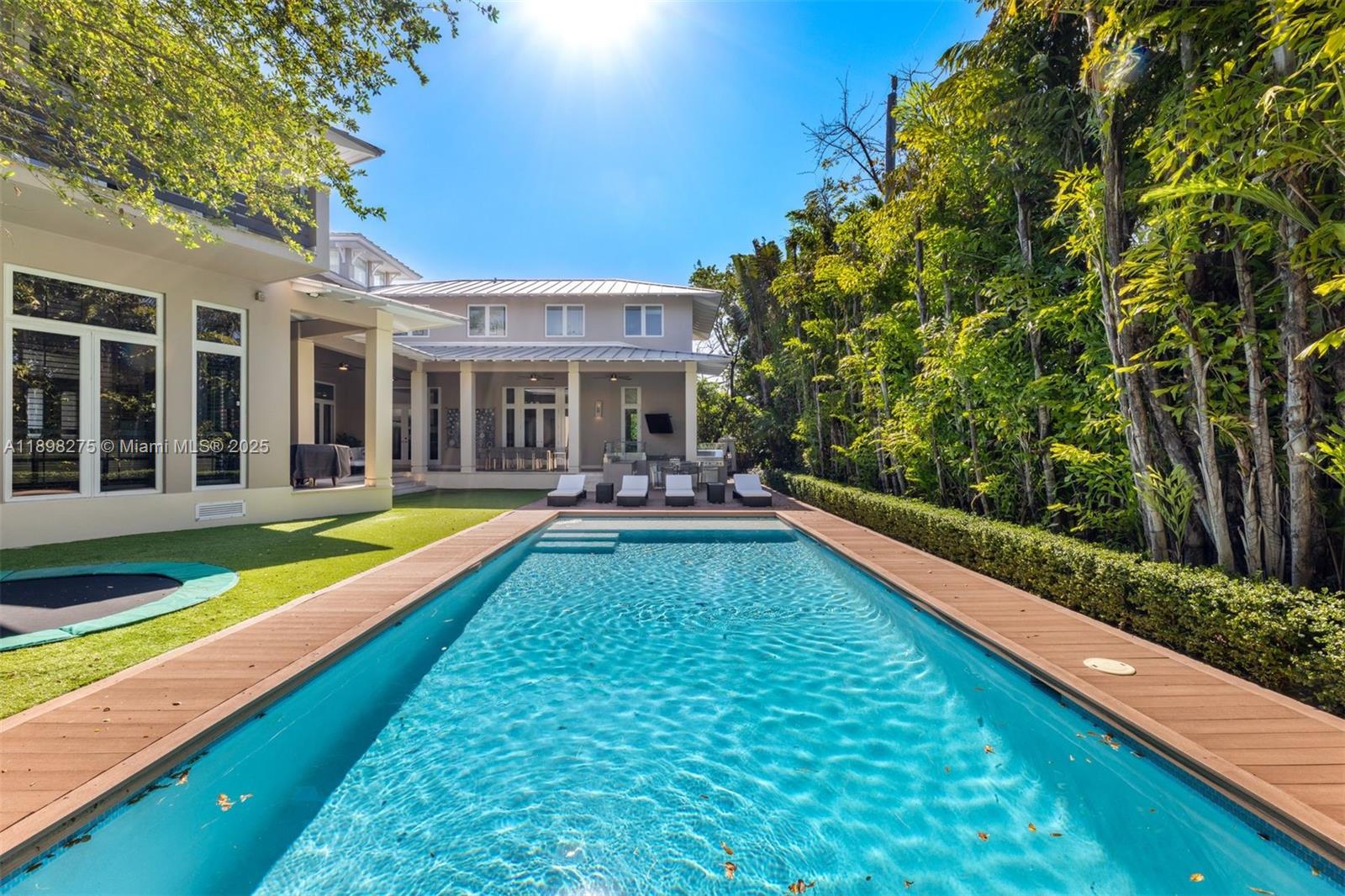 765 Allendale Road Key Biscayne, FL 33149 - Photo 27 of 29 a view of swimming pool with chairs and trees in the background