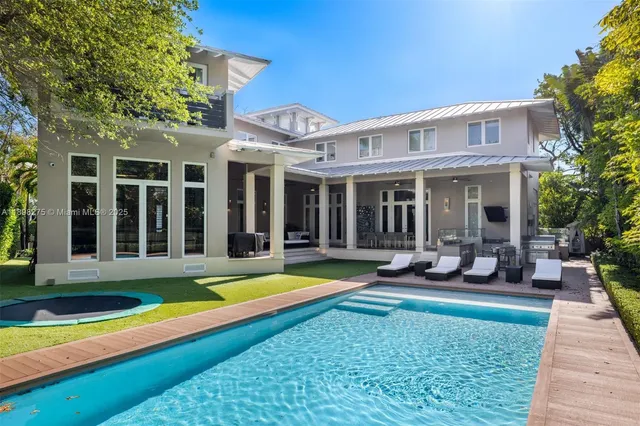 a view of a house with swimming pool and sitting area