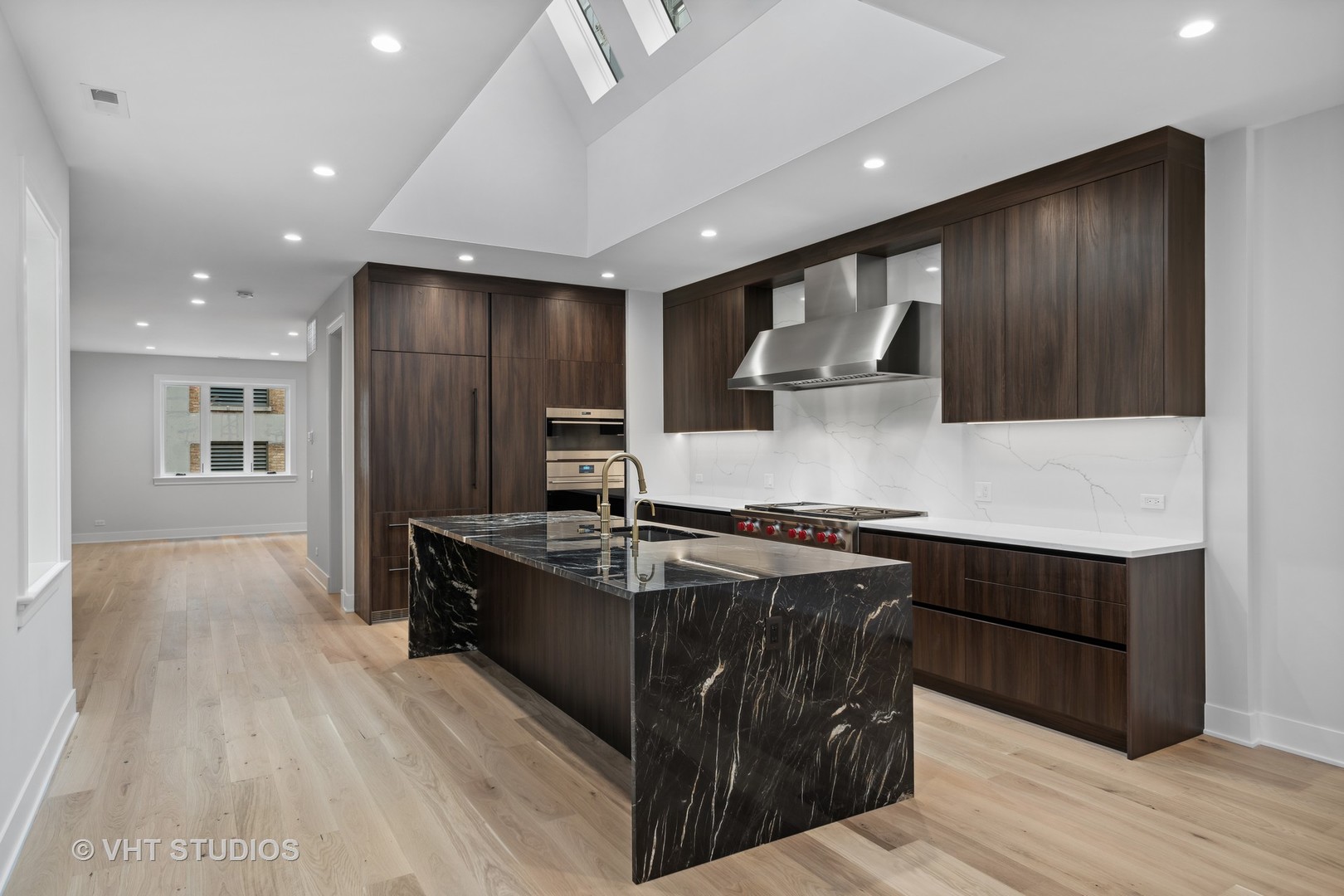 232 South Green Street, Unit 4S Chicago, IL 60607 - Photo 2 of 42 a kitchen with kitchen island granite countertop wooden cabinets and stainless steel appliances