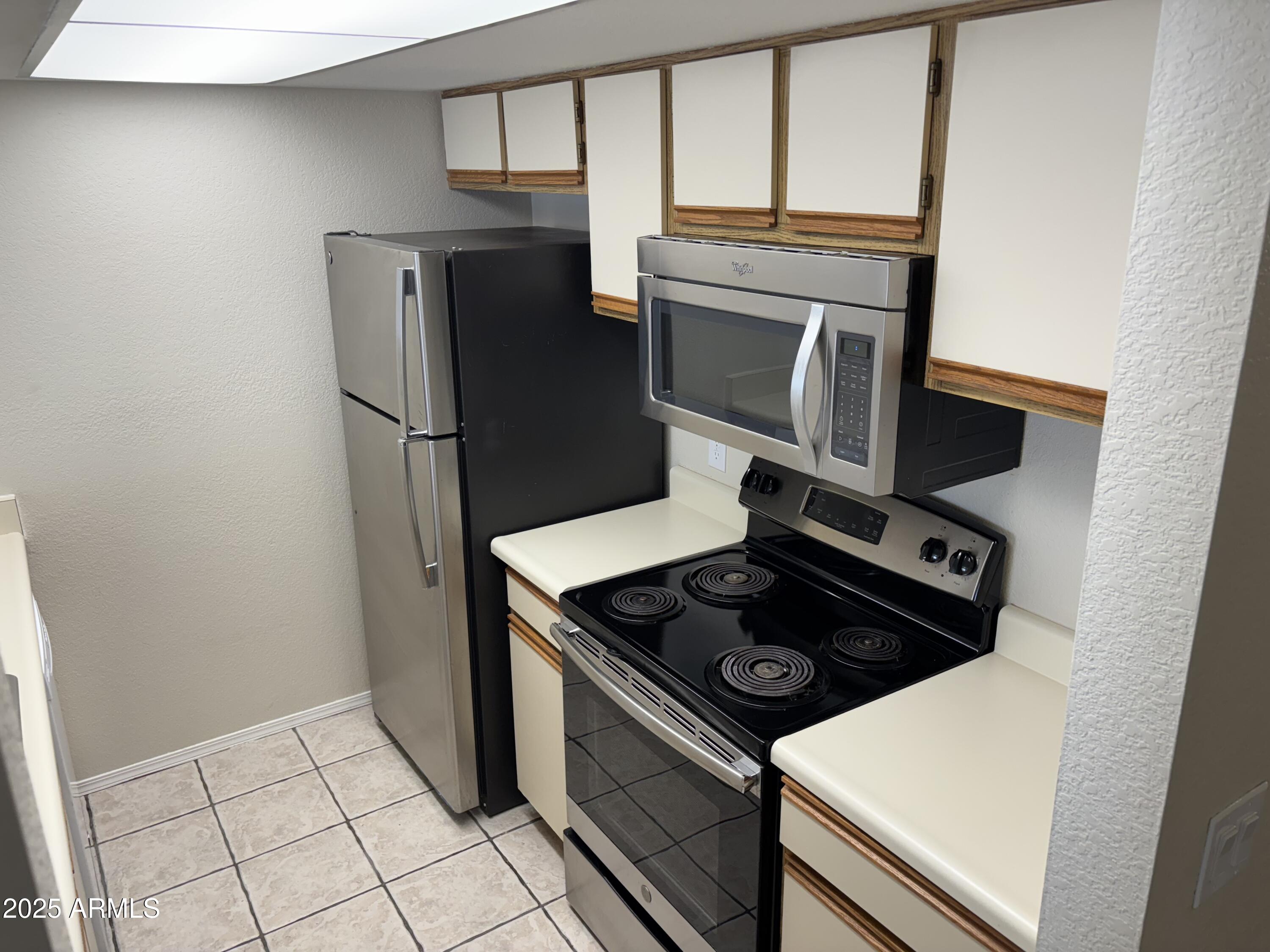 1444 North Recker Road, Unit 118 Mesa, AZ 85205 - Photo 5 of 22 a stove top oven sitting inside of a kitchen