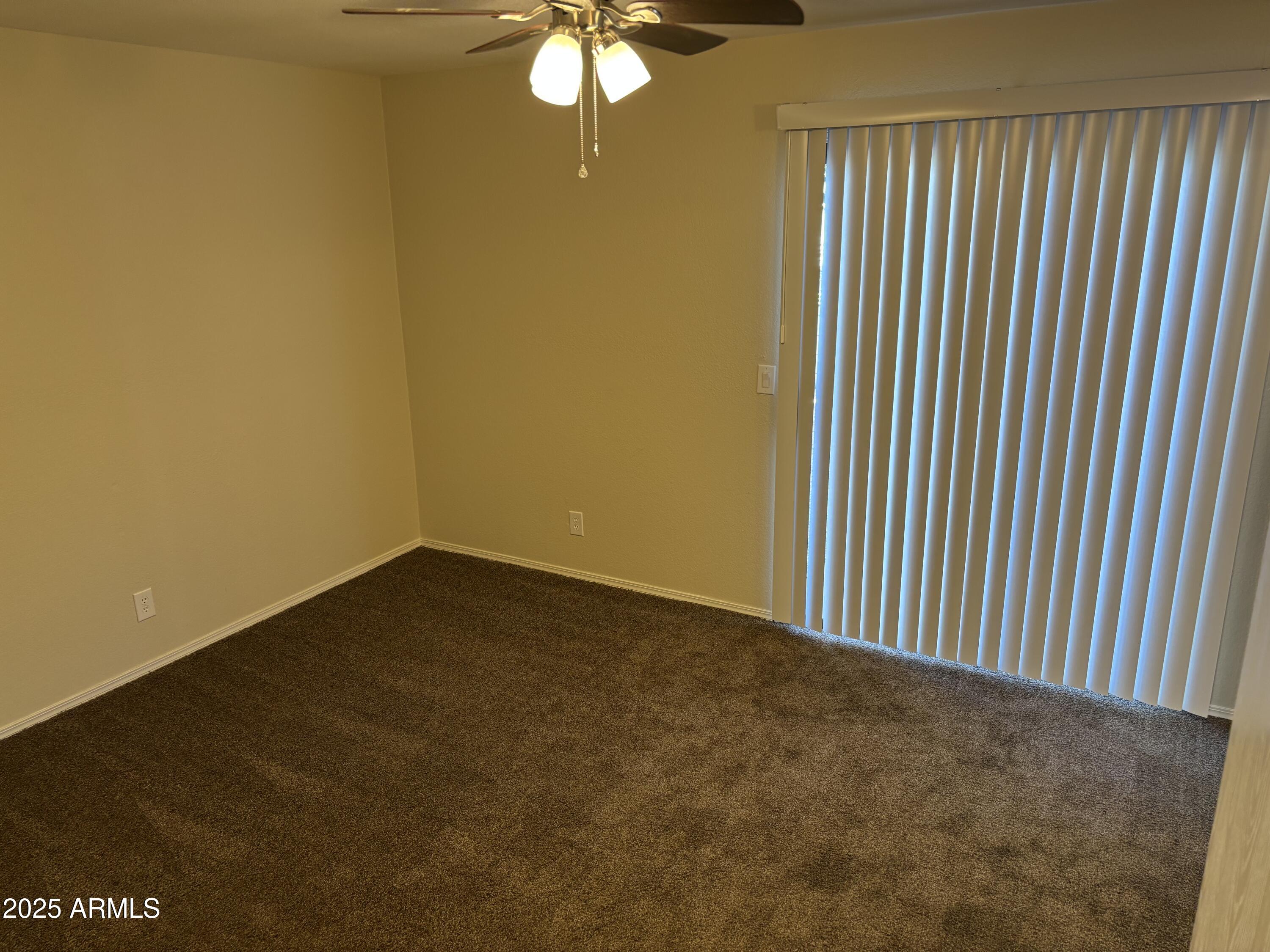 1444 North Recker Road, Unit 118 Mesa, AZ 85205 - Photo 9 of 22 a view of a livingroom with an empty space and a window