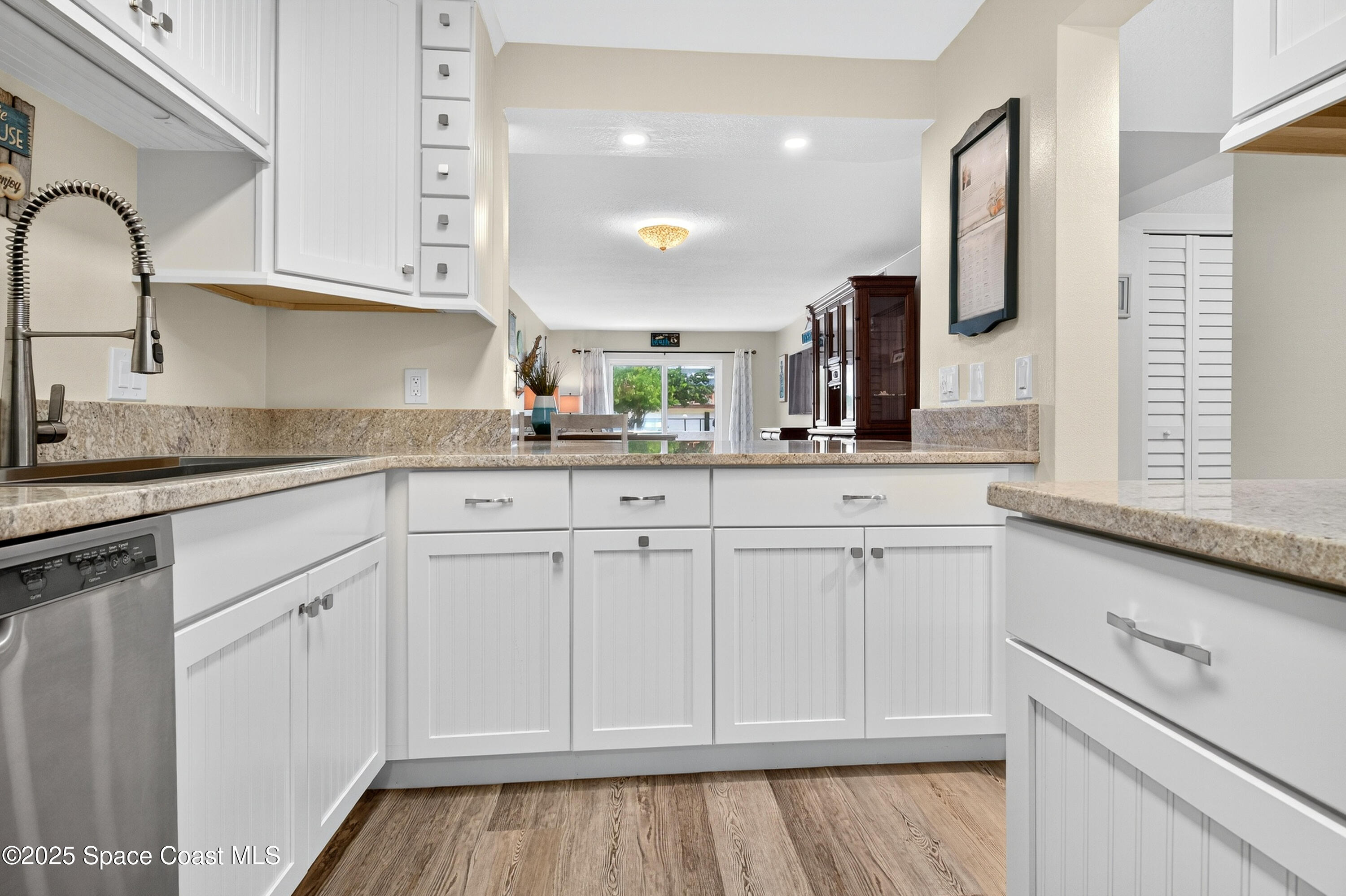 383 North Atlantic Avenue, Unit 105 Cocoa Beach, FL 32931 - Photo 13 of 67 a kitchen with white cabinets and sink