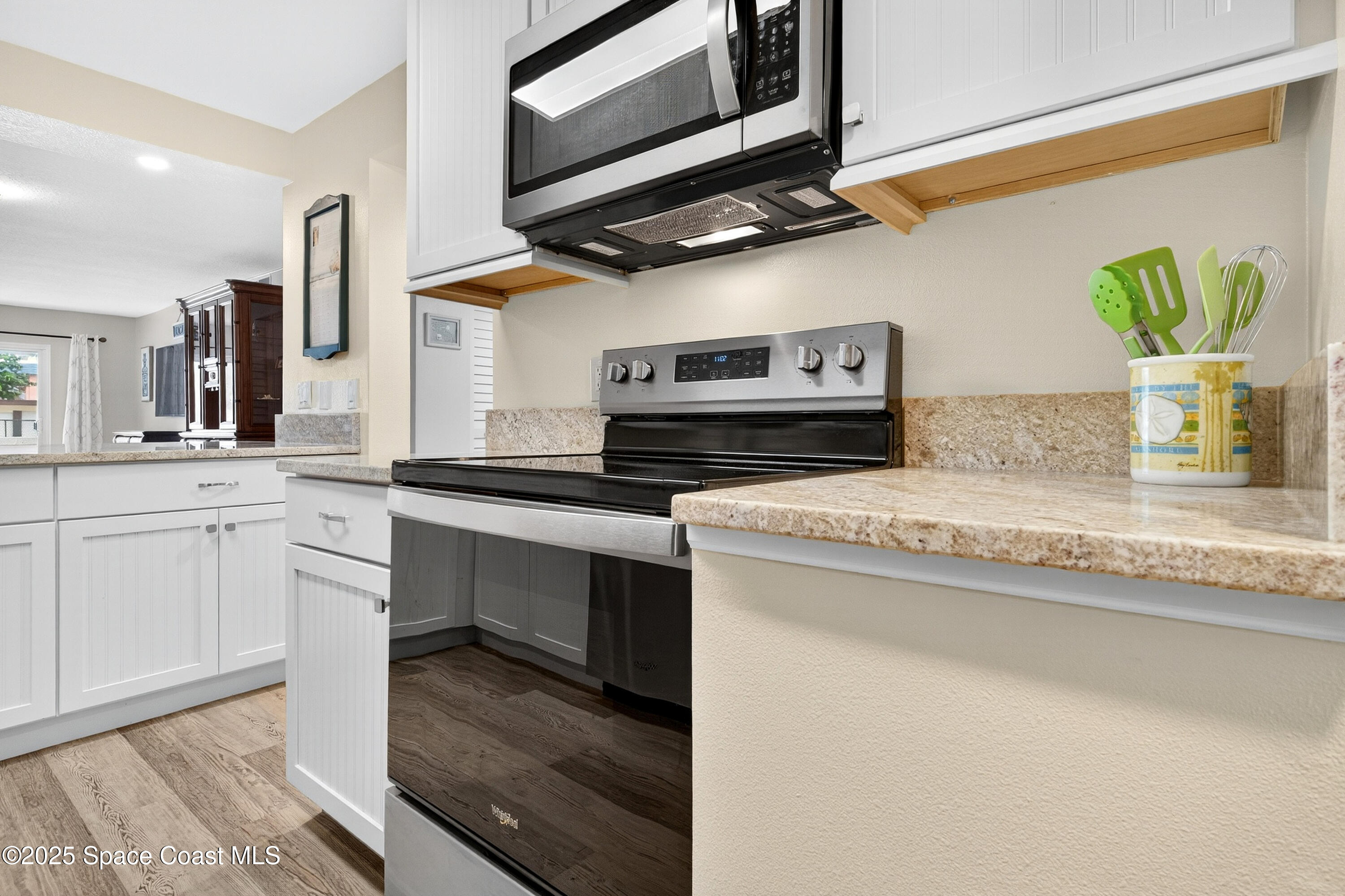 383 North Atlantic Avenue, Unit 105 Cocoa Beach, FL 32931 - Photo 14 of 67 a kitchen with stainless steel appliances granite countertop a sink a stove and cabinets