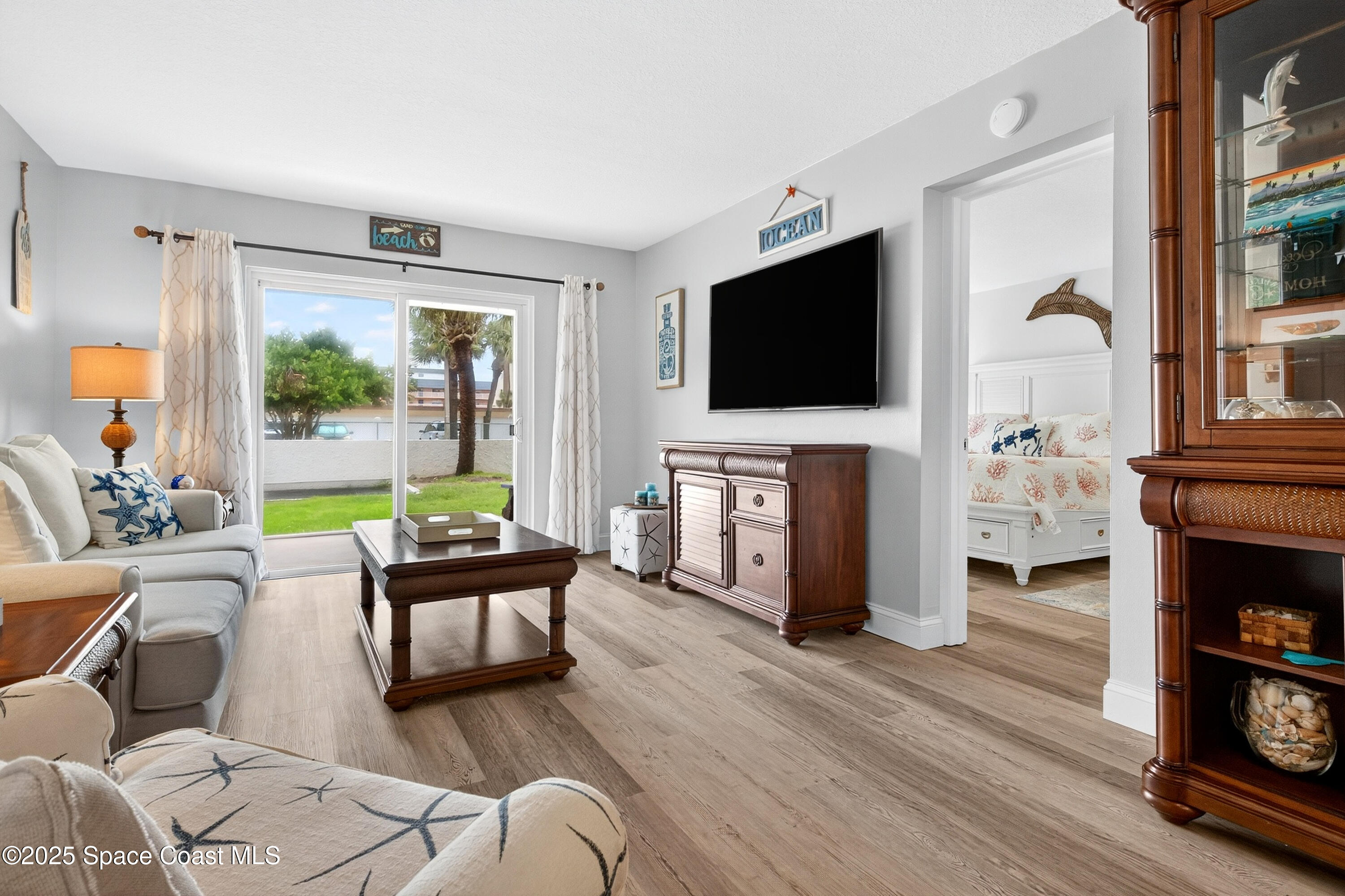383 North Atlantic Avenue, Unit 105 Cocoa Beach, FL 32931 - Photo 19 of 67 a living room with fireplace furniture and a flat screen tv