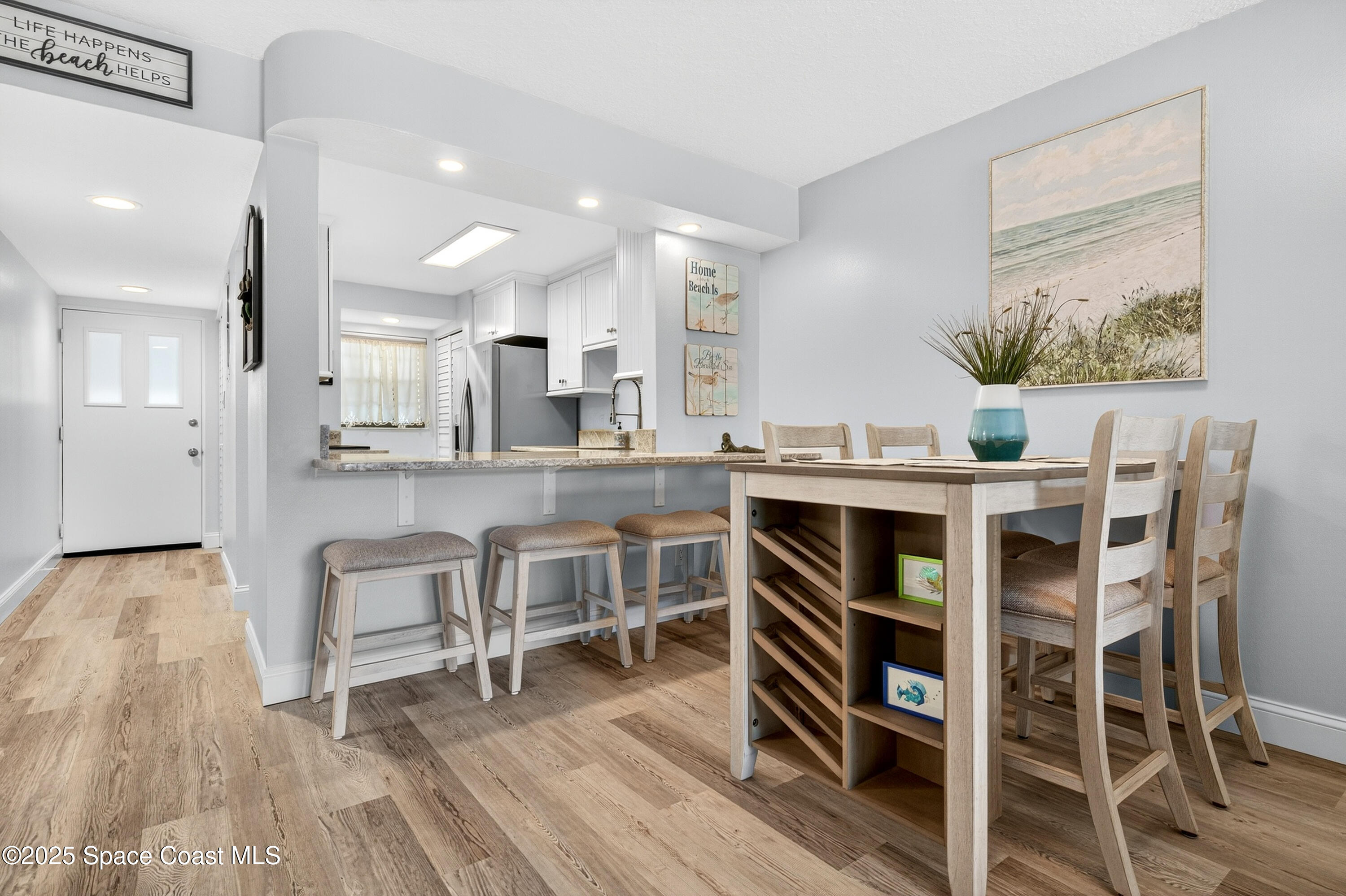 383 North Atlantic Avenue, Unit 105 Cocoa Beach, FL 32931 - Photo 20 of 67 a view of a dining room with furniture and wooden floor