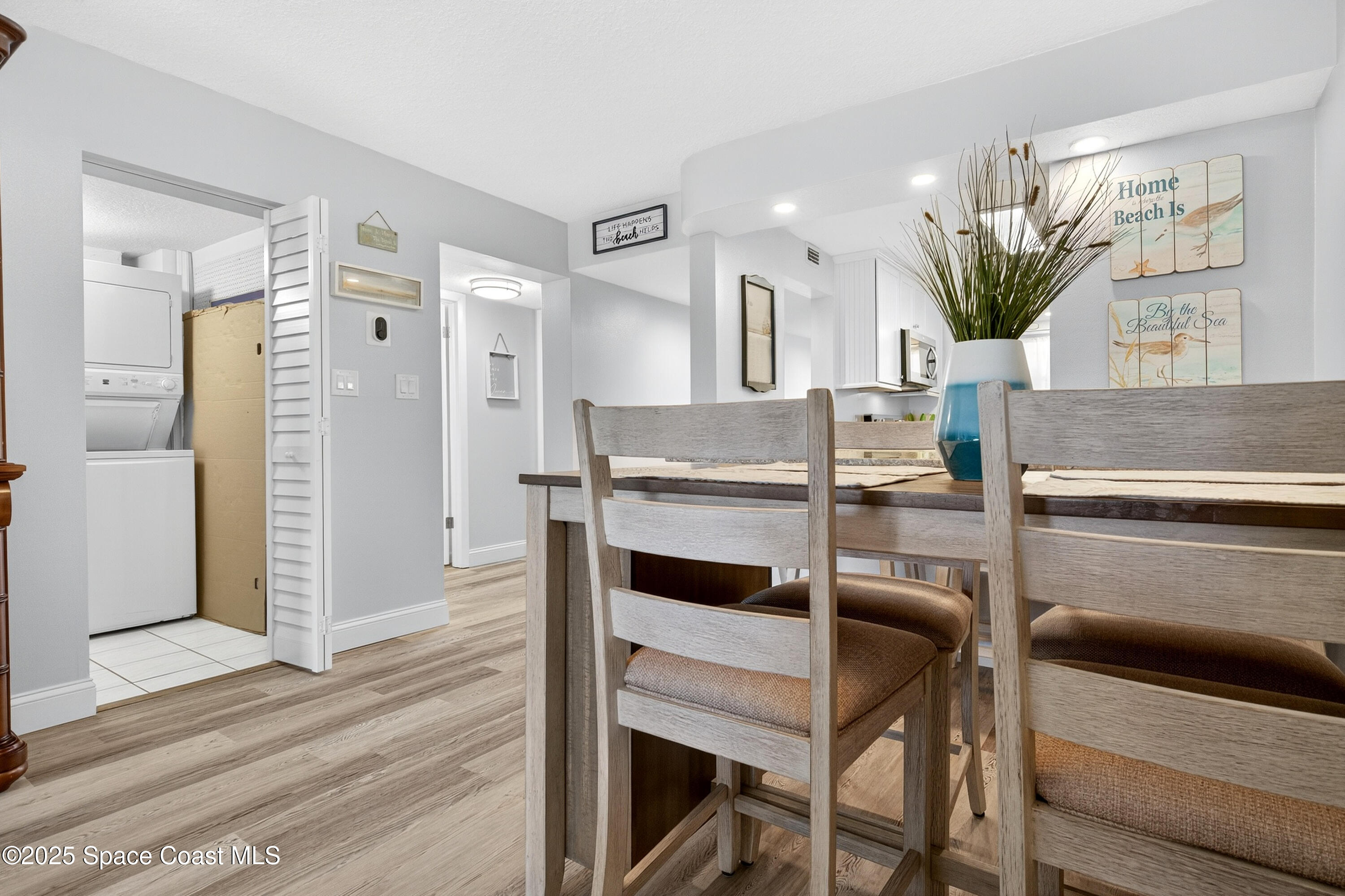 383 North Atlantic Avenue, Unit 105 Cocoa Beach, FL 32931 - Photo 21 of 67 a view of kitchen with kitchen island dining table and chairs