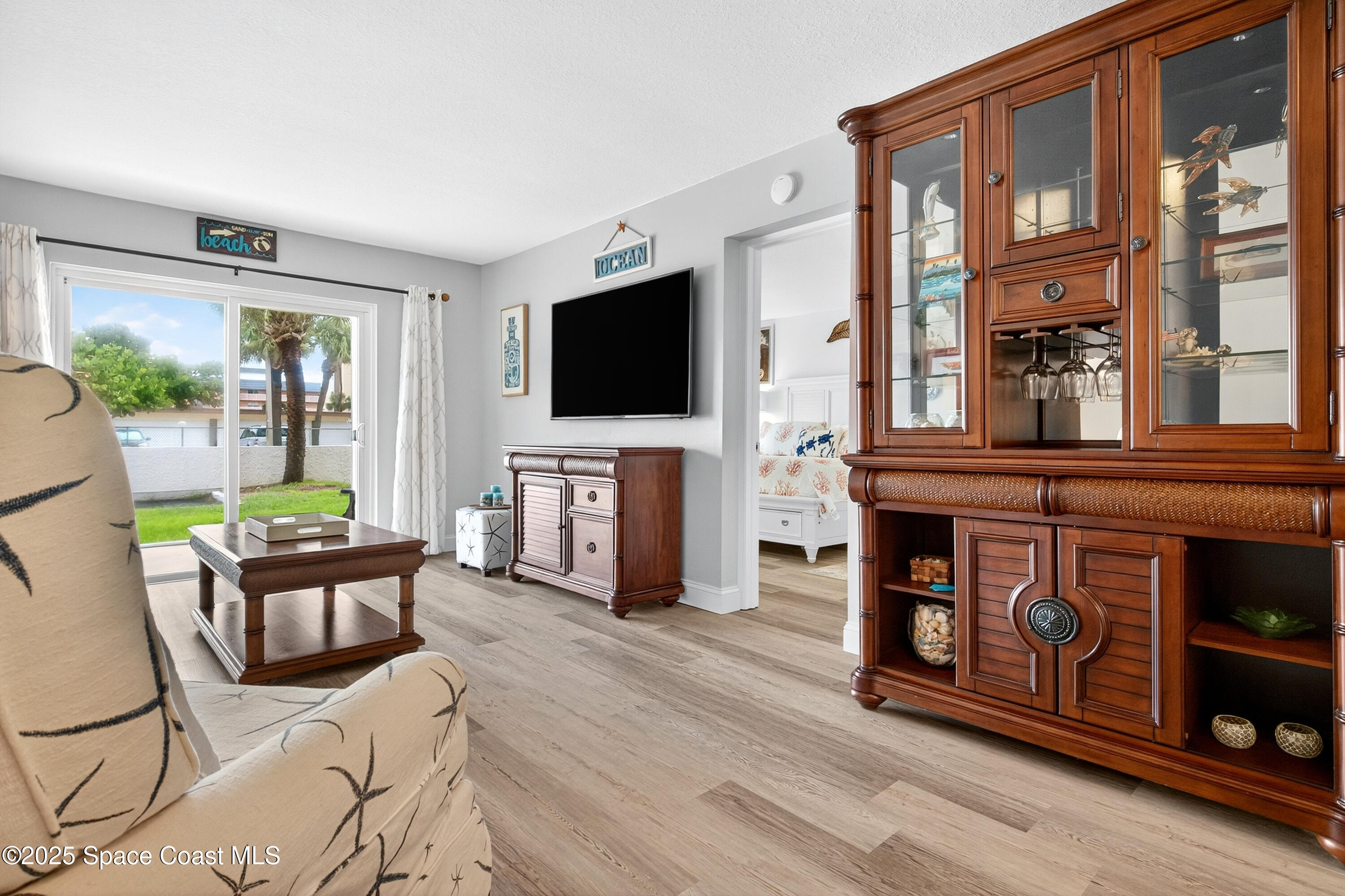 383 North Atlantic Avenue, Unit 105 Cocoa Beach, FL 32931 - Photo 23 of 67 a living room with furniture a flat screen tv and a fireplace