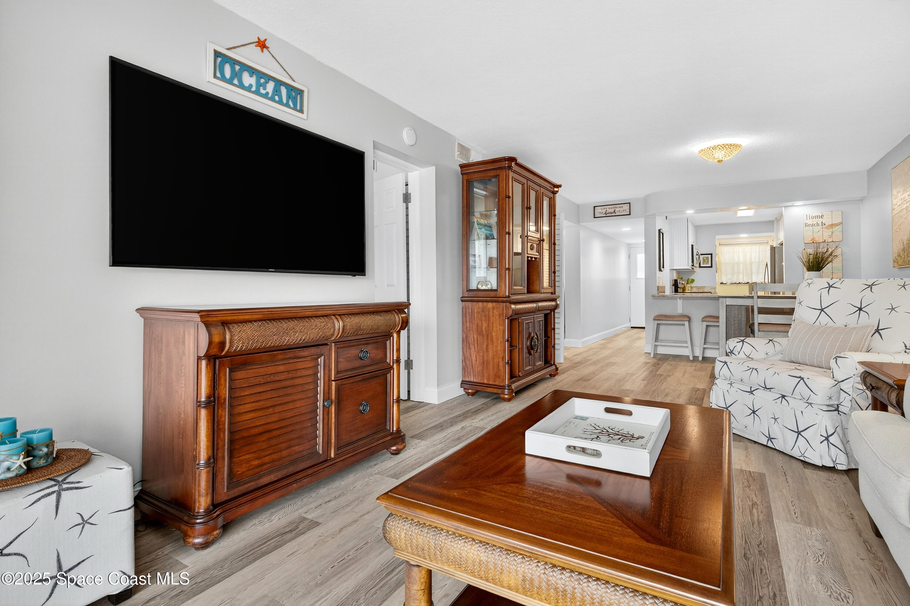 383 North Atlantic Avenue, Unit 105 Cocoa Beach, FL 32931 - Photo 27 of 67 a living room with furniture and a flat screen tv