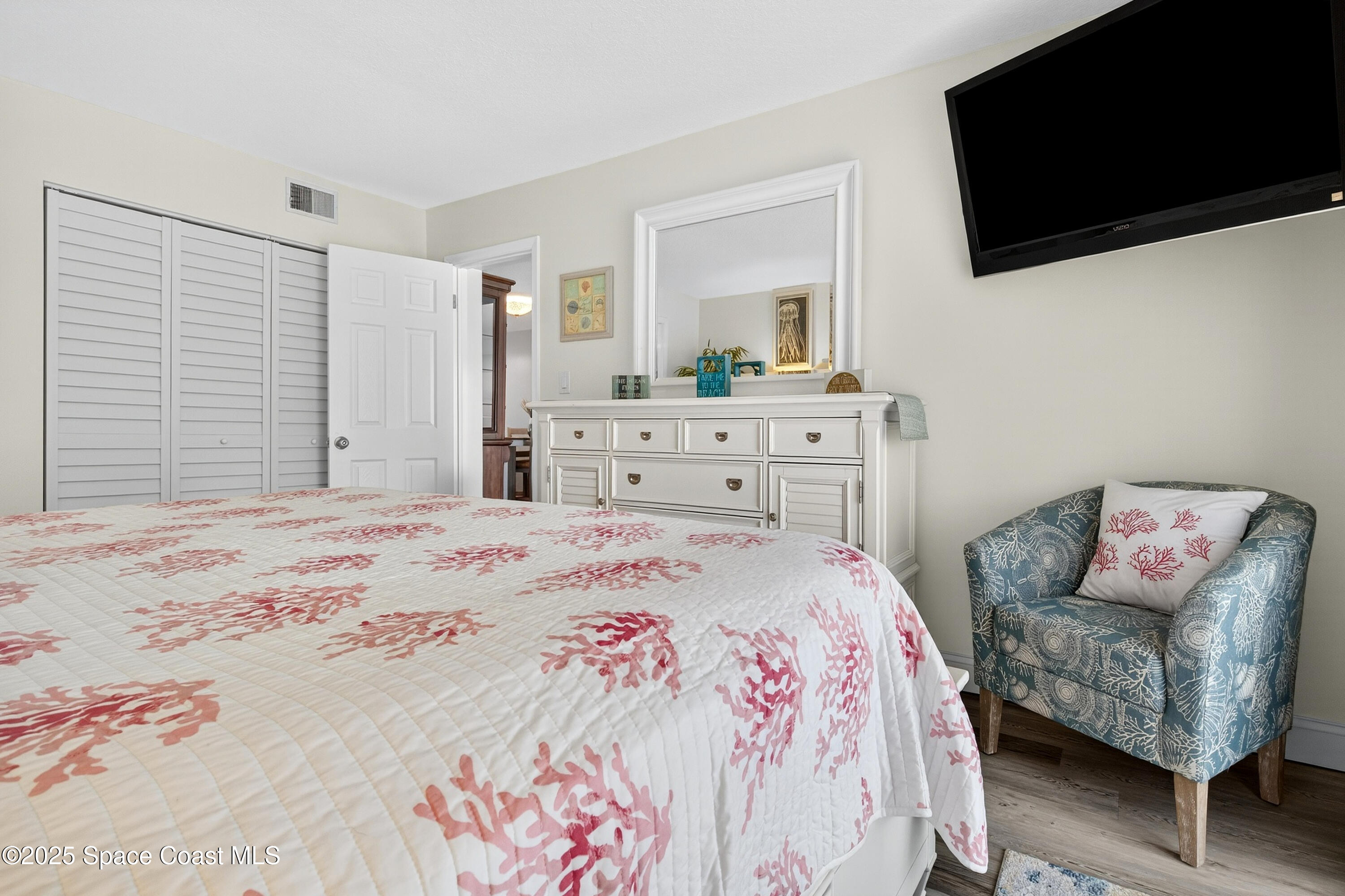 383 North Atlantic Avenue, Unit 105 Cocoa Beach, FL 32931 - Photo 33 of 67 a bedroom with a bed and a flat screen tv