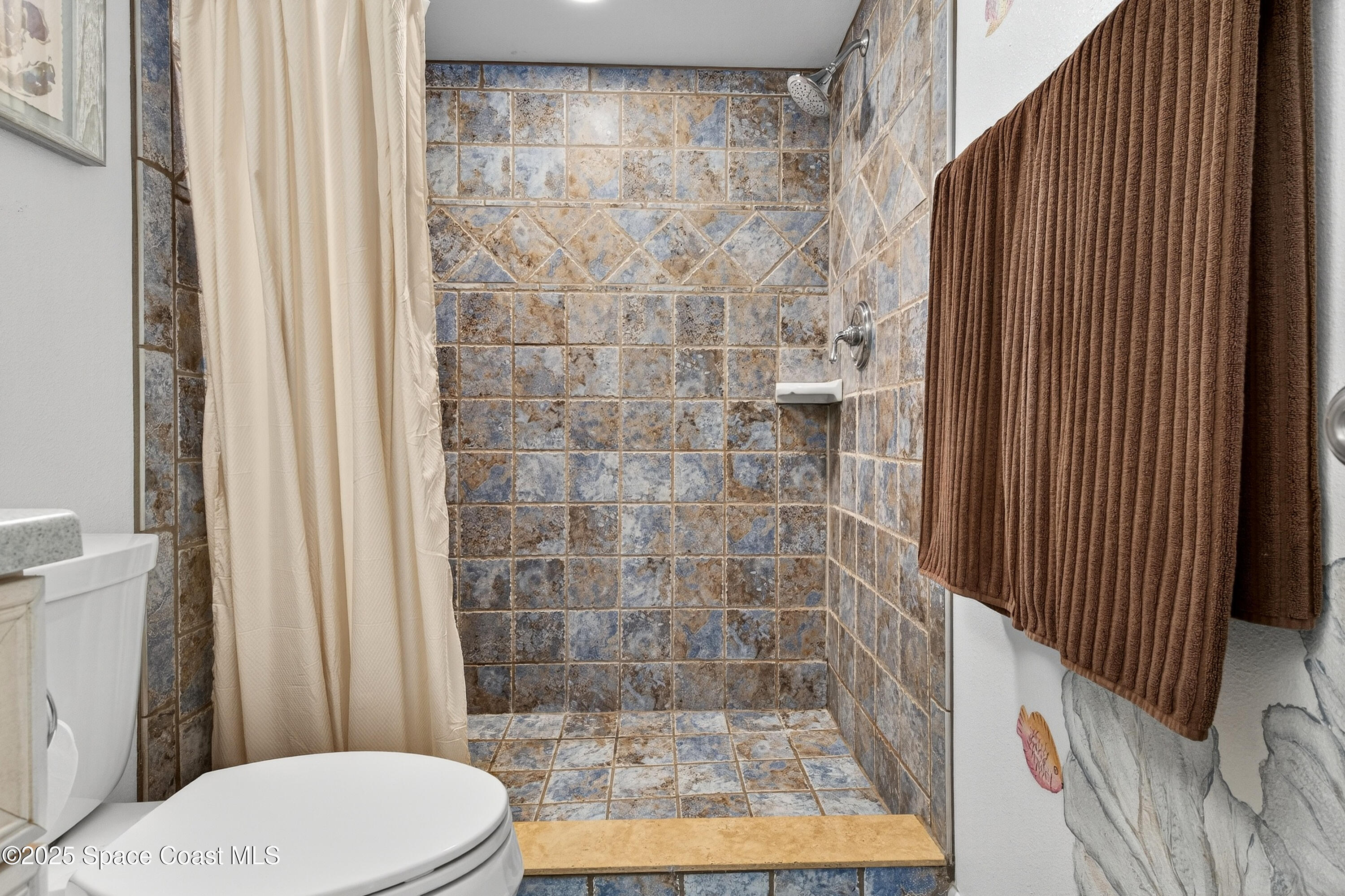 383 North Atlantic Avenue, Unit 105 Cocoa Beach, FL 32931 - Photo 35 of 67 a bathroom with a toilet and shower