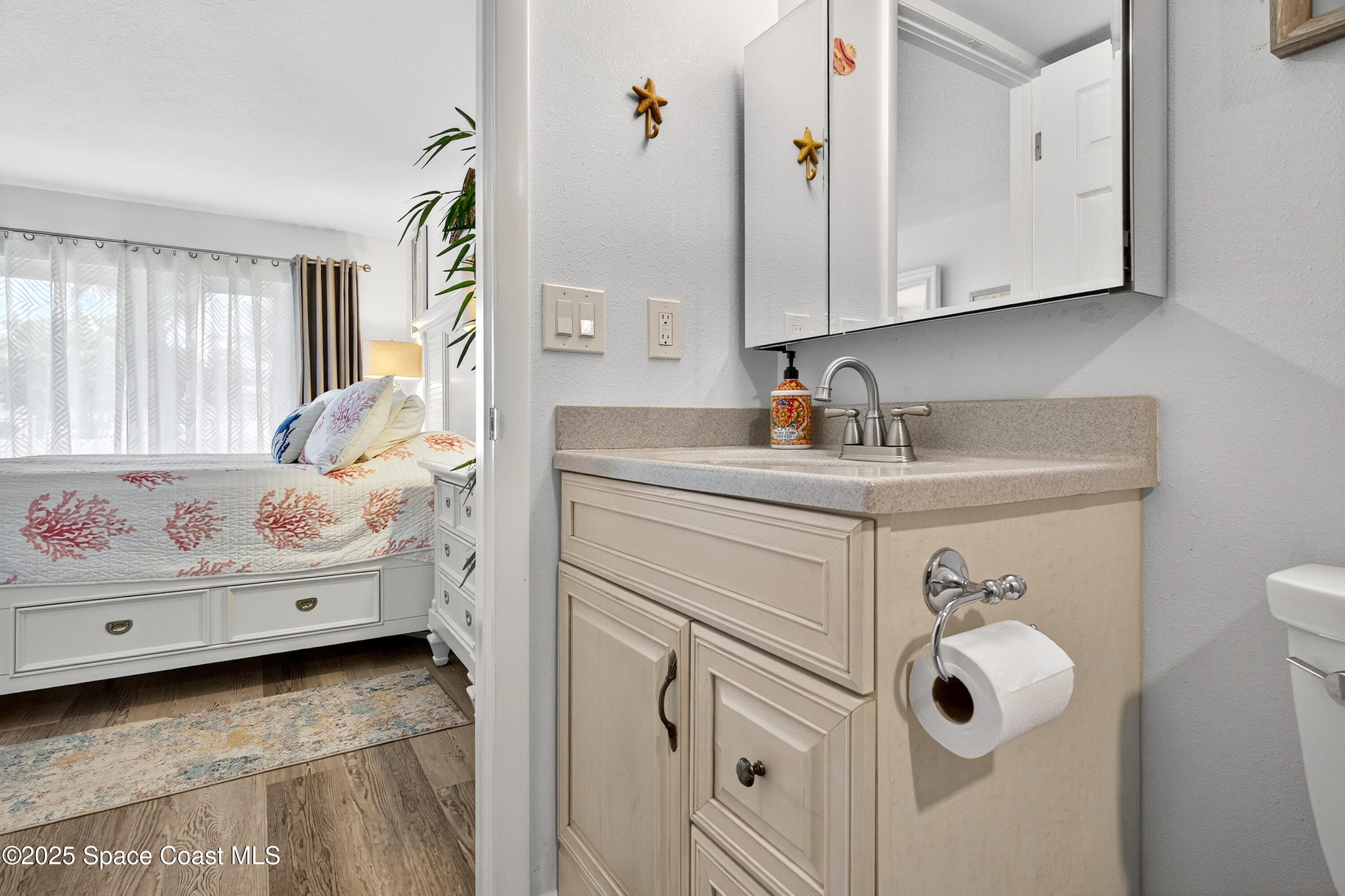 383 North Atlantic Avenue, Unit 105 Cocoa Beach, FL 32931 - Photo 36 of 67 a bathroom with a sink vanity and mirror