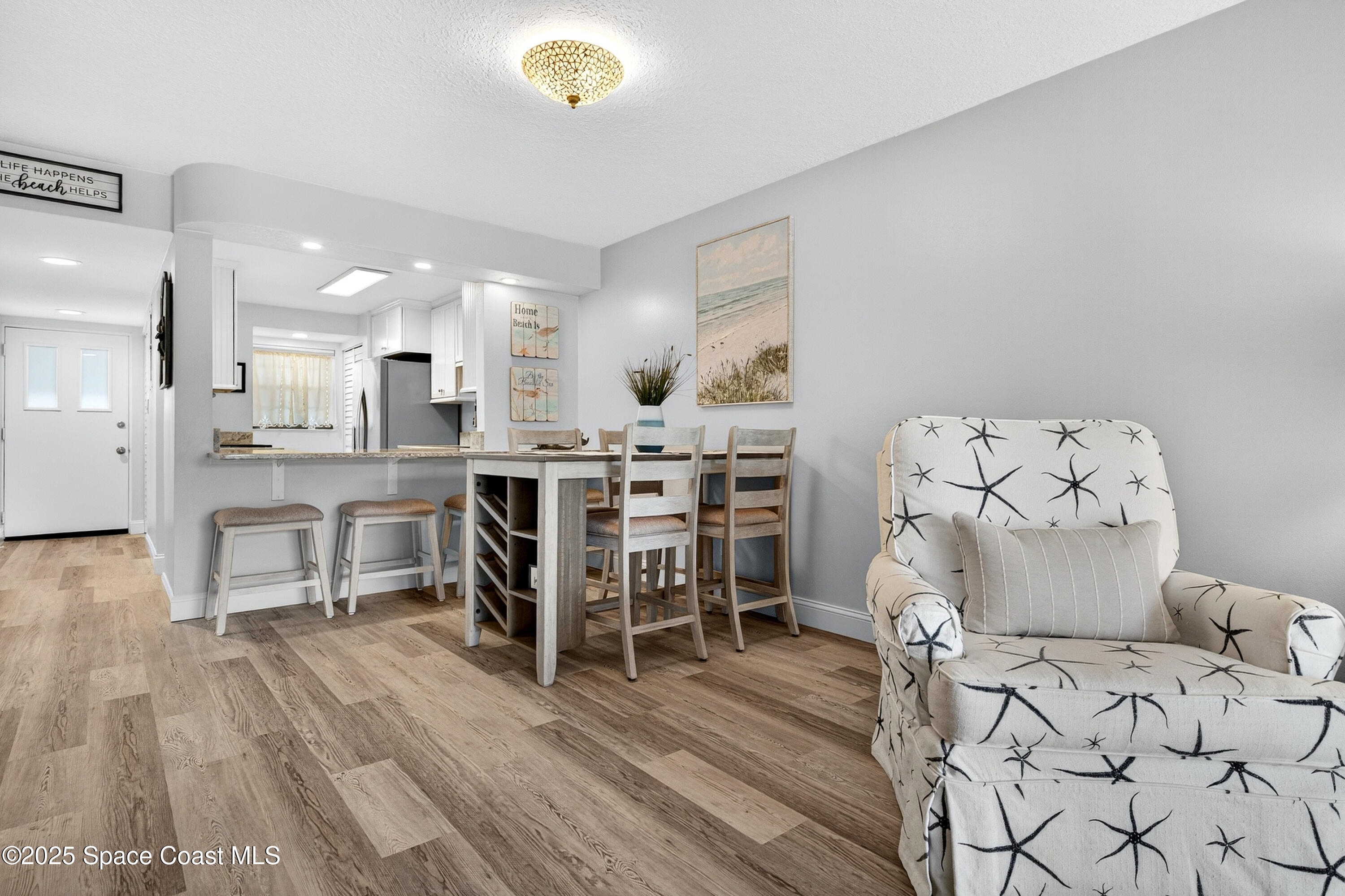 383 North Atlantic Avenue, Unit 105 Cocoa Beach, FL 32931 - Photo 37 of 67 a living room with furniture and kitchen view