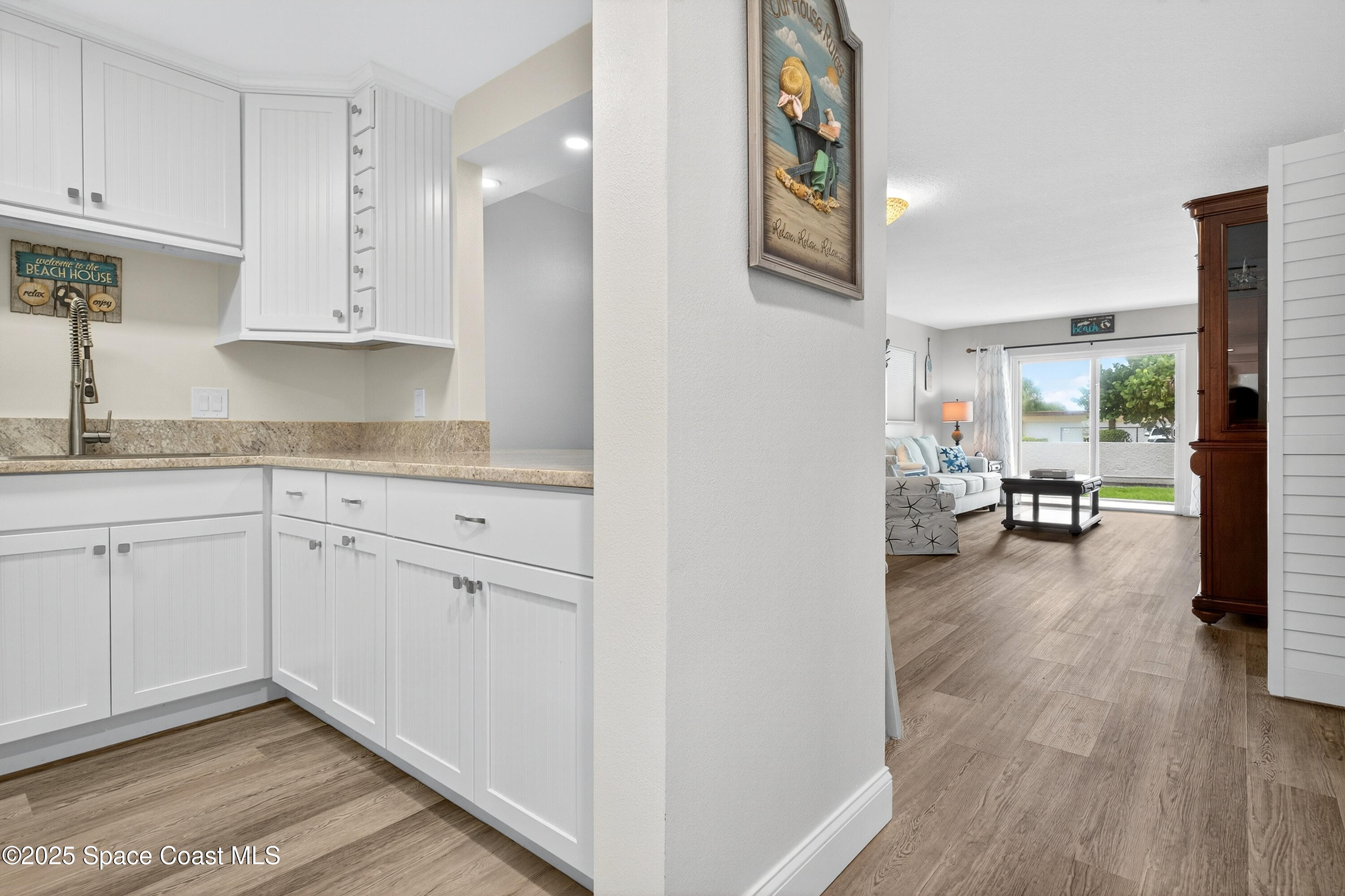 383 North Atlantic Avenue, Unit 105 Cocoa Beach, FL 32931 - Photo 7 of 67 a view of a kitchen with wooden floor and electronic appliances